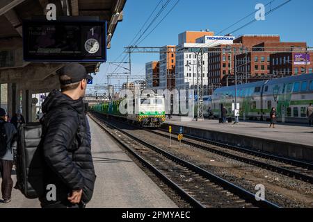 Ein Mann steht auf dem Bahnsteig und beobachtet, wie sich der Güterzug am Hauptbahnhof Tampere in Tampere, Finnland, nähert Stockfoto
