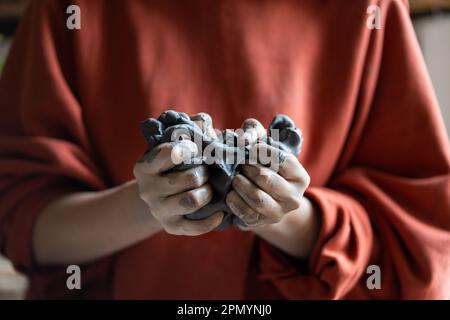 Handkneten von SkulpturenLehm zur Herstellung von Figuren in der Keramikmeisterklasse in der Werkstatt Stockfoto