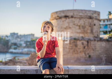 Junge Touristen, die türkisches Eis im Hintergrund des Hidirlik-Turms in Antalya vor dem Hintergrund der mediterranen Bucht der alten Kaleici essen Stockfoto