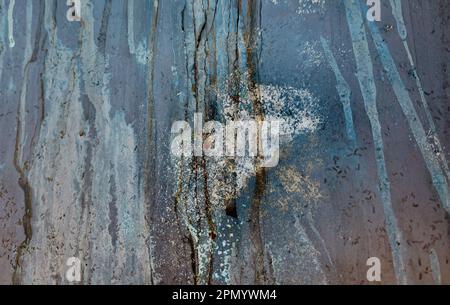 Nahaufnahme abstrakter vertikaler rostiger Fleckenstreifen auf blauer Lackstruktur Stockfoto