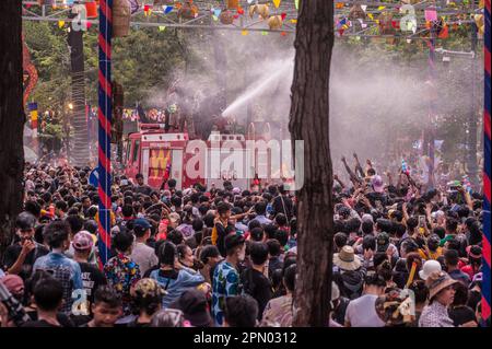 Während des kambodschanischen Neujahrsfestes spritzt ein Feuerwehrauto Wasser über eine dicht besiedelte Menschenmenge. Wat Phnom, Phnom Penh, Kambodscha. © Kraig Stockfoto