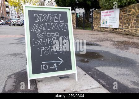 Handgeschriebenes Schild für eine Modelleisenbahn-Ausstellung in einer Dorfkirche in Leigh on Sea, Essex, Großbritannien. Kreidebeschriftung an der Tafel Stockfoto