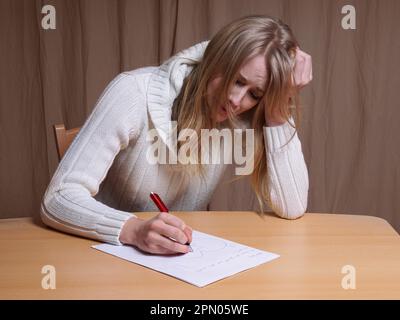 Verliebte junge Frau schreiben Brief mit gebrochenen Herzen Stockfoto