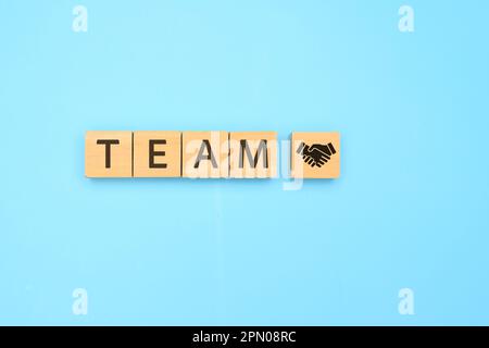 Teamwork-Text auf Holzwürfel mit abstraktem blauem Hintergrund Stockfoto