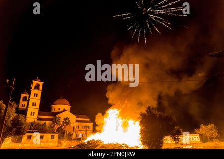 Limassol, Zypern. 15. April 2023. Ein Feuerwerk explodiert über einem großen Feuer namens "Lampratzia", das das Böse verbannen soll, und brennt vor einer Kirche, Limassol, Zypern, am 15. April 2023. Orthodoxe Christen feiern die Auferstehung Jesu Christi mit einer Zeremonie, die um Mitternacht stattfindet, am Wechsel vom Heiligen Samstag zum Ostersonntag. (Foto: Kostas Pikoulas/Sipa USA) Kredit: SIPA USA/Alamy Live News Stockfoto