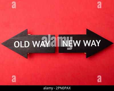 Holzpfeil mit dem Wort OLD WAY NEW WAY auf rotem Hintergrund Stockfoto