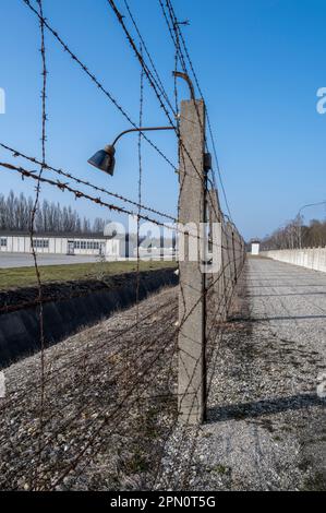 Bereich zwischen der Betonwand und dem elektrischen Stacheldrahtzaun mit einem Graben vor dem Drahtzaun, der eine Flucht unmöglich macht Stockfoto