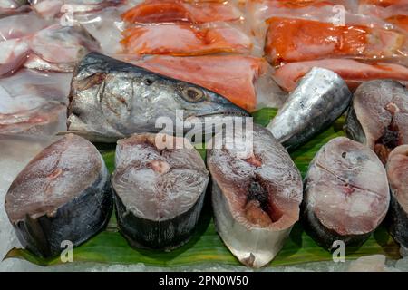 Schneiden Sie gefrorenen Thunfisch auf die Bananenblätter im Supermarkt in Yogyakarta, Indonesien Stockfoto