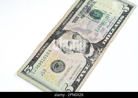 Die Gegenseite einer zerrissenen 5-Dollar-Banknote, repariert mit Pflaster, mit dem Porträt von Präsident Abraham Lincoln, dem alten amerikanischen Geld Stockfoto