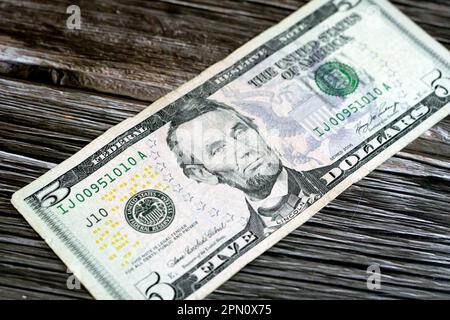 Die Gegenseite einer zerrissenen 5-Dollar-Banknote, repariert mit Pflaster, mit dem Porträt von Präsident Abraham Lincoln, dem alten amerikanischen Geld Stockfoto