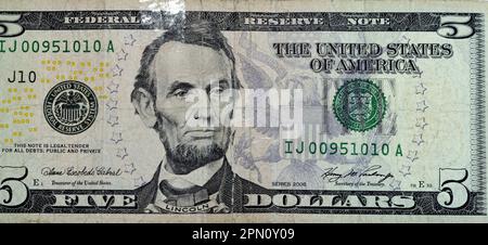 Ein großes Fragment der Rückseite einer zerrissenen 5-Dollar-Banknote, repariert mit Pflaster mit dem Porträt von Präsident Abraham Lincol Stockfoto