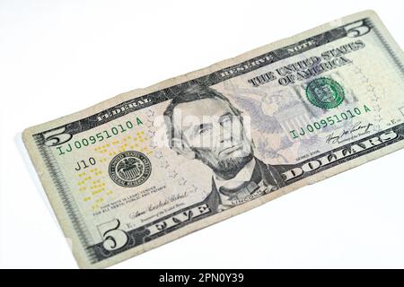 Die Gegenseite einer zerrissenen 5-Dollar-Banknote, repariert mit Pflaster, mit dem Porträt von Präsident Abraham Lincoln, dem alten amerikanischen Geld Stockfoto