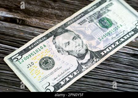 Die Gegenseite einer zerrissenen 5-Dollar-Banknote, repariert mit Pflaster, mit dem Porträt von Präsident Abraham Lincoln, dem alten amerikanischen Geld Stockfoto