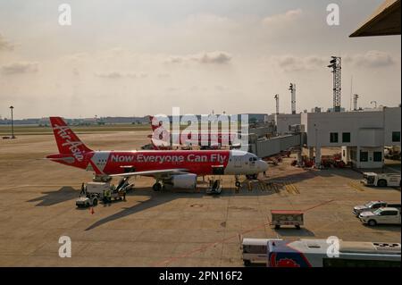 Bangkok, Thailand - 2. März 2023: Zwei AirAsia-Flugzeuge am Don Mueang International Airport, die Passagiere und Gepäck befördern. Stockfoto