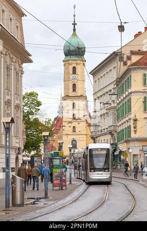 Graz, Österreich - Mai 28 2019: Straßenbahn von der Franziskanerkirche (Österreich: Franziskanerkirche Graz) im Stadtzentrum. Stockfoto