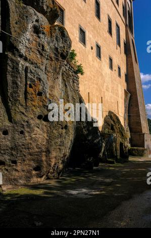 Felsenfest: Diese Ecke des Renaissance-Palastes aus dem Jahr 1500s, erbaut von der mächtigen Familie Orsini in Bomarzo, Latium, Italien, folgt den Konturen der riesigen vulkanischen Felsbrocken auf dem Hügel. Unter dem Palazzo schuf Vicino Orsini den bizarren Parco del Mostri (Park der Monster), eine groteske Manierist-Skulptur in einem Terrassengarten, der später seiner Frau Giulia Farnese gewidmet war. Stockfoto