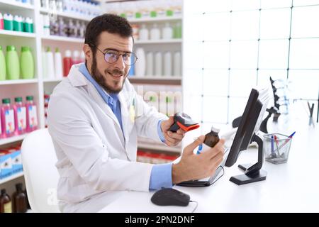 Junger hispanischer Apotheker-Scanning-Medikamentenflasche in der Apotheke Stockfoto