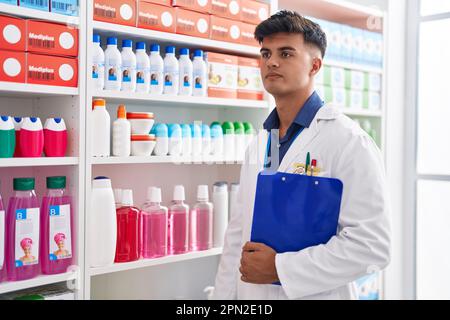 Junger hispanischer Apotheker mit Klemmbrett in der Apotheke Stockfoto