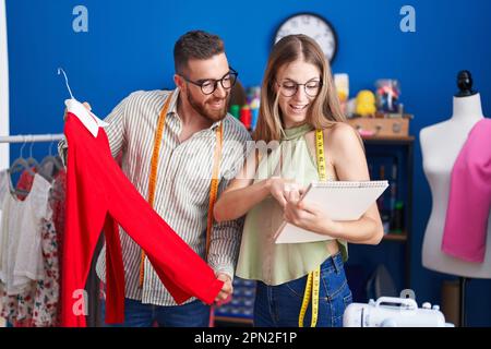In der Bekleidungsfabrik Schneiderinnen und Schneiderinnen, die T-Shirt im Look halten Stockfoto