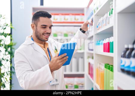Junger hispanic-Mann Apotheker mit Touchpad in der Apotheke arbeiten Stockfoto