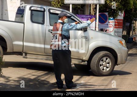 SAMUT PRAKAN, THAILAND, JANUAR 21 2023, Sicherheitsbeamter regulieren den Verkehr für die Möglichkeit, dass ein Auto auf die Hauptstraße gelangt Stockfoto