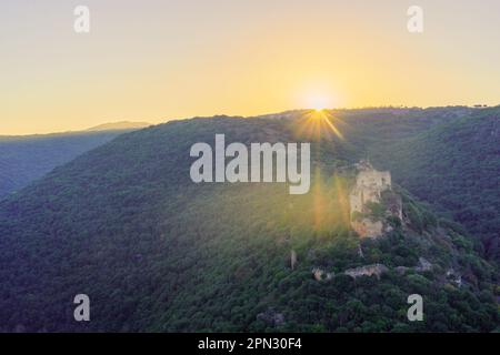 Der Blick auf die Sonne geht über dem Kreuzritter Montfort Castle und dem Kziv-Tal im oberen Galiläa im Norden Israels auf Stockfoto