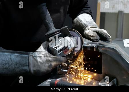 Blick auf die Hände eines Arbeiters, der ein Stück Metall schleift, Frankreich Stockfoto