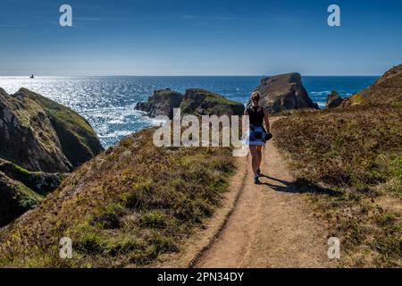 Junge Frau Auf Dem Küstenwanderweg Mit Spektakulären Klippen Auf Der Halbinsel Pointe Du Van Auf Cap Sizun An Der Finistere Atlantikküste In Der Bretagne, Frankreich Stockfoto
