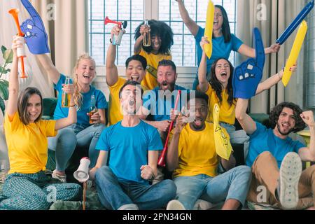 Ziel. Sehr aufgeregte Freunde, die Spaß dabei haben, sich ein Fußballspiel anzusehen und zu Hause zu essen, drinnen. Freundschaft, Vergnügen, Ruhe, Heim-Party-Konzept Stockfoto