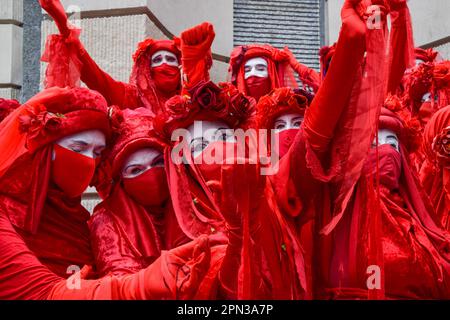 London, Vereinigtes Königreich. 27. August 2021. Die Red Rebel Brigade der Extinction Rebellion tritt auf dem Paternoster Square auf. Demonstranten versammelten sich außerhalb der Londoner Börse, als Teil ihres Blutgeldmarsches, der die City of London angreift. Stockfoto