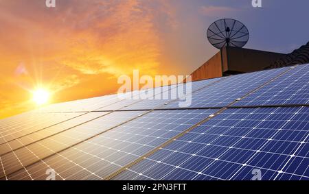 Sonnenkollektoren und elektrische Windturbinen bei Sonnenuntergang. Erneuerbare, saubere und nachhaltige Energie für Wirtschaft und Leben. Stockfoto