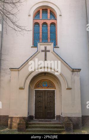 Eine Jahrhunderte alte Kirchentür und ein gewölbtes Kirchenfenster in einer Stadtkirche, Hertogenbosch, Provinz Nordbrabant, Niederlande Stockfoto