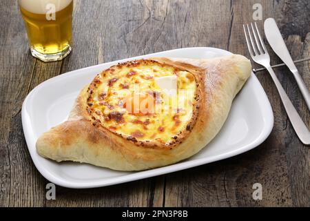 Hausgemachtes adjaruli khachapuri ( Ein bootförmiges traditionelles Käsebrot aus der Region Adjara in Georgien ), horizontale Position Stockfoto