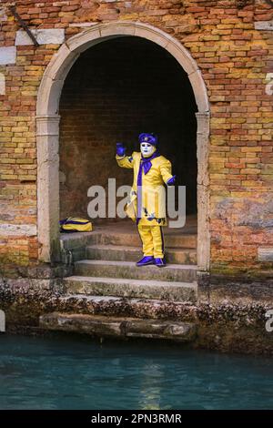 Venedig Karneval, kostümierter Teilnehmer in bunten, schicken Kleiderständern an einem Kanal, Venedig, Italien, Europa Stockfoto