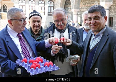 Yusuf Karabulut (L), Präsident der Mar Petyun Chaldean Church Foundation in Diyarbakir, und Ohannes Gafur Ohanian (R), Vizepräsident der Surp Giragos Armenian Church Foundation, tauschen bei einer Feier in der Jungfrauenkirche in Diyarbakir rote Eier aus. Die letzten Assyrer von Diyarbakir, bestehend aus zwei Familien und insgesamt 12 Personen, feierten die Osterferien mit einer Messe in der Jungfrau-Maria-Kirche. Der Pfarrer Behnam Konutgan, der aus dem Kloster Mardin Deyrul Zaferan in Auftrag gegeben wurde, weil es in der Stadt keinen Geistlichen gab, der das Ritual durchführen konnte, führte die Regie. Stockfoto