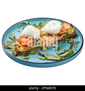 Frühstücksmenü im Restaurant, pochierte Eier auf Mehrkornbrot mit geräuchertem Lachs, Guacamole und Salatmischung Stockfoto