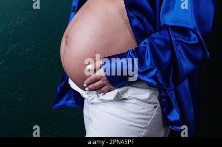 Porträt einer schwangeren Weißen, die ihre Hände an der Babybrücke hält. Stockfoto