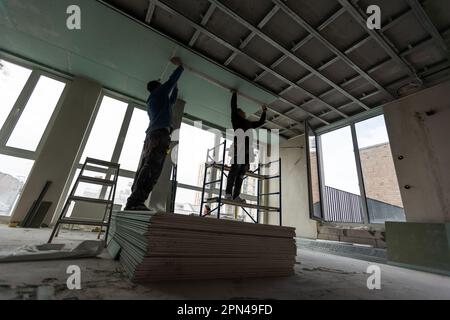 Drywall Installers. Men holding a gypsum board figured cut Stockfoto