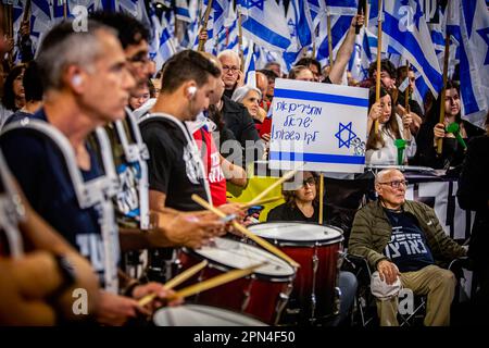 Netanya, Israel. 15. April 2023. Ein israelischer Demonstrant hält ein Plakat auf Hebräisch, auf dem "Israel wieder in seinen Verstand zurückdrängt" während einer Anti-Reformen-Demonstration in Netanya nördlich von Tel Aviv steht. Hunderttausende Menschen versammelten sich für die 15. Woche in Folge gegen Netanjahus Pläne für die richterliche Überarbeitung der Koalition, einen Tag, nachdem die führende Ratingagentur Moody's Israels wirtschaftliche Aussichten von positiv auf stabil heruntergestuft hatte, inmitten der höchst umstrittenen Vorschläge der Koalition, die Justiz zu fesseln. Kredit: SOPA Images Limited/Alamy Live News Stockfoto