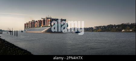 Großes Containerschiff kommt bei sonnigem Wetter im Hamburger Hafen an Stockfoto