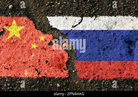 Auf dem Bürgersteig befinden sich Bilder der Flaggen Chinas und Russlands als Symbol der Konfrontation. Konzeptionelles Bild. Stockfoto