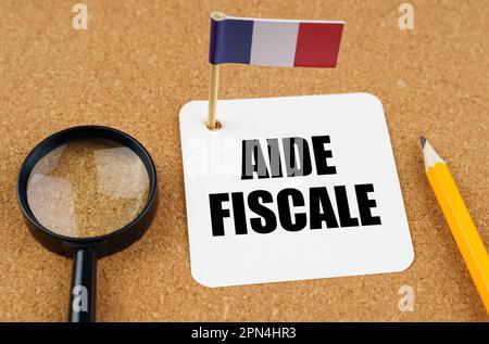 Auf dem Tisch liegt die Fahne Frankreichs, ein Bleistift, eine Lupe und ein Blatt Papier mit einer Inschrift auf Französisch, die ins Englische übersetzt wird als... Stockfoto