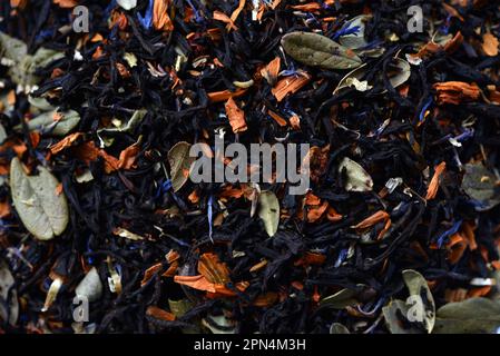 Nahaufnahme schwarzer Tee. Trockener Tee mit Gewürzen zum Brühen. Stockfoto
