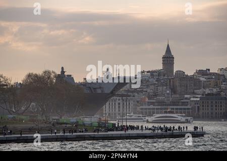 Istanbul, Türkei. 16. April 2023. Das größte Kriegsschiff der Türkei, TCG Anadolu, mit dem Galata-Turm im Hintergrund. Das weltweit erste bewaffnete unbemannte Luftfahrtschiff (SIHA) und das größte Kriegsschiff der Türkei, das Mehrzweck-Amphibienschiff TCG Anadolu, wirft Anker im Hafen von Sarayburnu, während es für öffentliche Besuche im türkischen Istanbul öffnet. TCG Anadolu ist vom 17. Bis 23. April für Besucher geöffnet. Kredit: SOPA Images Limited/Alamy Live News Stockfoto