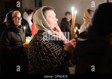 Ein Gläubiger, der eine Kerze in der Hand hält, schaut zum Ausgang, um PR Daniel vor der Kirche zu folgen. Die Gläubigen der Gemeinde der Verkündigung, die Kirche, die von Rumänen des orthodoxen Glaubens von Ostia Lido besucht wird, nehmen am Ritual des Heiligen Feuers Teil. Der Ritus des Heiligen Feuers, am heiligen Samstag der Kirchen, die dem julianischen Kalender folgen, auf der Höhe des Ostertriduums für die orthodoxen Gläubigen aus der ganzen Welt, Findet seit mindestens sechs Jahrhunderten auf die gleiche Weise statt und stammt aus der Konstantinskirche im 4. Jahrhundert. Dies ist der Vorschlag des Stockfoto