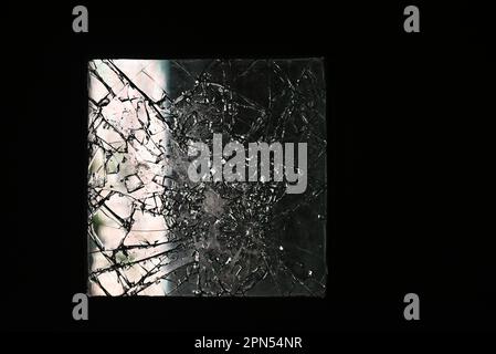 Eine kaputte Fensterscheibe in einer Tür einer Schule, die seit 2001 verlassen wurde. Stockfoto