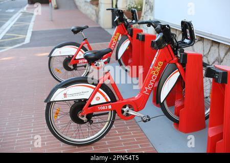 Monte-Carlo, Monaco - 16. April 2023: Zwei Elektrofahrräder von MonaBike, die an ihren Ladestationen in Monaco angedockt sind, zeigen das Engagement des Fürstentums Stockfoto