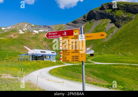 Wegweiser für Fahrräder und Wanderer mit Laufzeiten am Grindelwald-First in der Jungfrau-Region der Berner Oberlandalpen, Schweiz Stockfoto