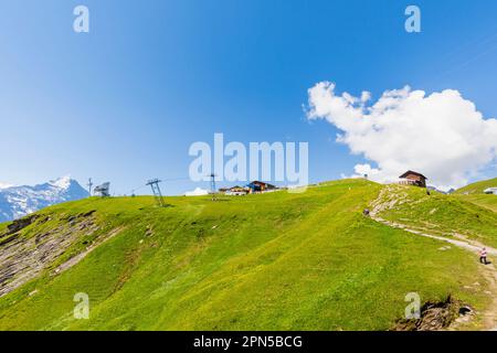 Blick auf die Seilbahnstation Grindelwald-First und die Region Eiger, Jungfrau in den Berner Oberlandalpen, Schweiz im Sommer Stockfoto