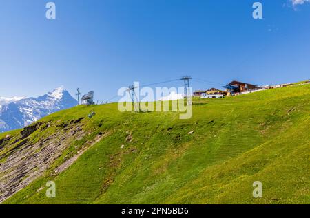 Blick auf die Seilbahnstation Grindelwald-First und die Region Eiger, Jungfrau in den Berner Oberlandalpen, Schweiz im Sommer Stockfoto